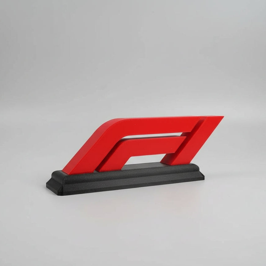 Red and black logo-like object on a wooden surface with a white background