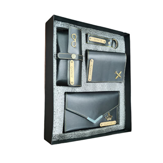 Set of black wallets with gold accents in a decorative box on a light pink background.