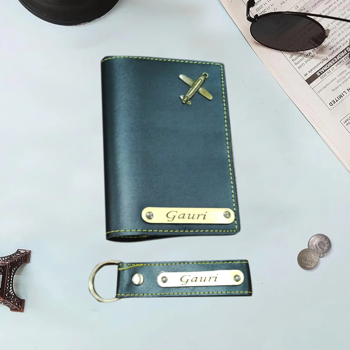 Green leather wallet with airplane emblem and 'Gauri' engraving on a light gray background