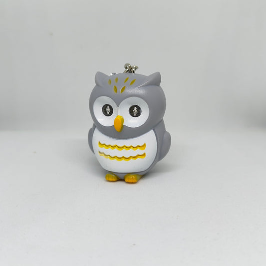 Gray owl-shaped keychain with yellow accents on a white background