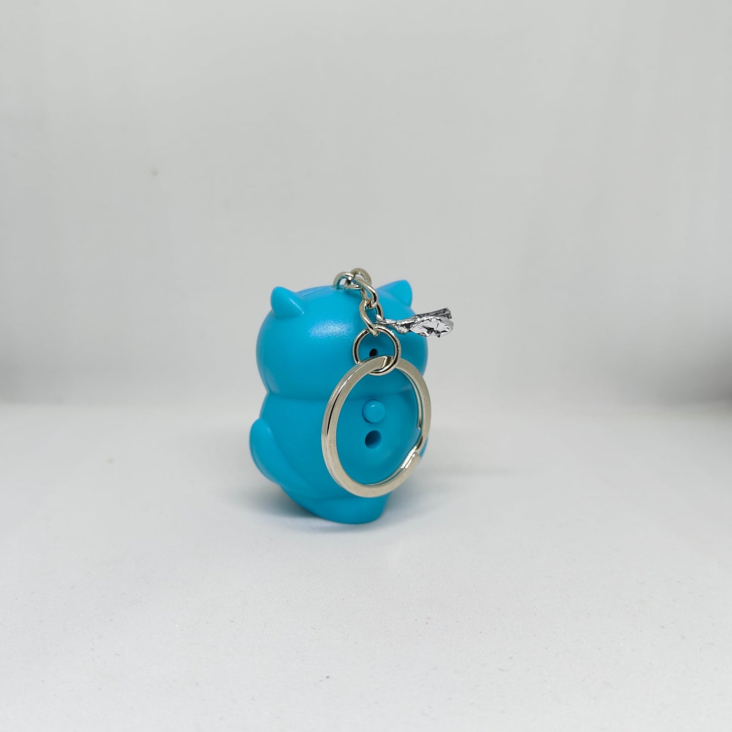 Blue owl-shaped keychain on a white background