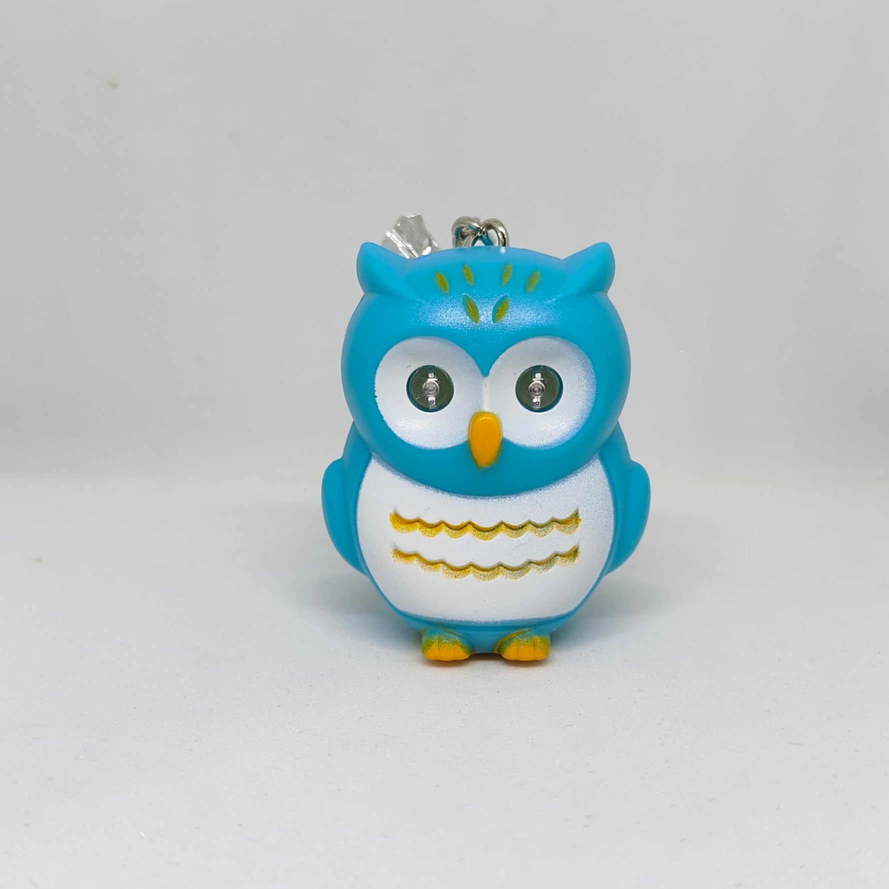 Blue owl-shaped keychain on a white background