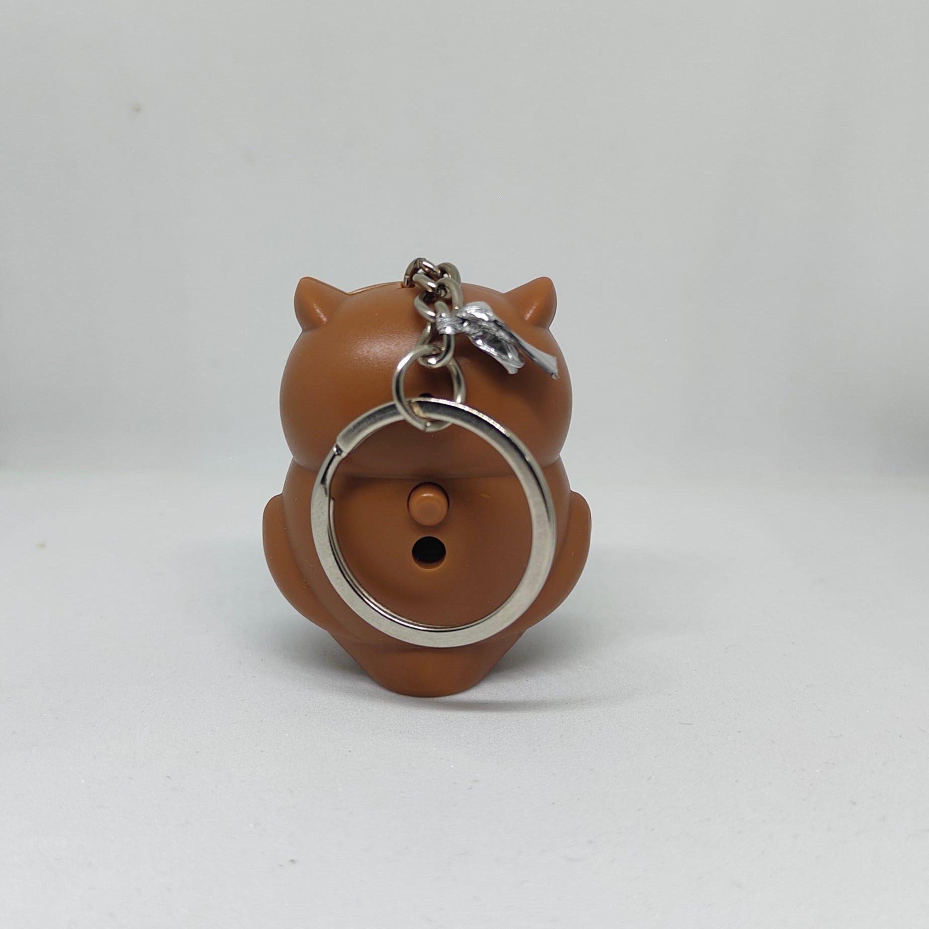 Brown owl-shaped keychain on a white background