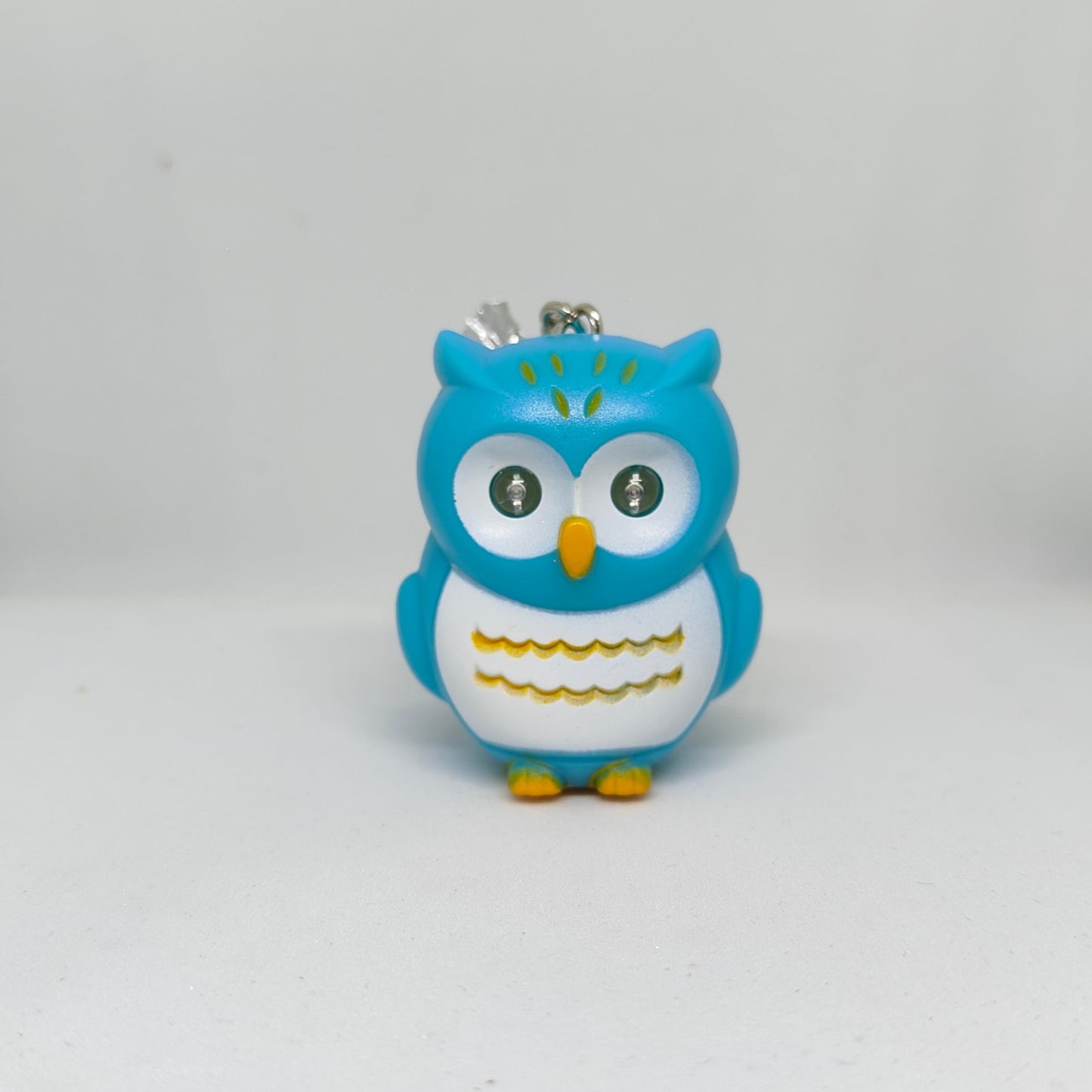 Blue owl-shaped keychain on a white background