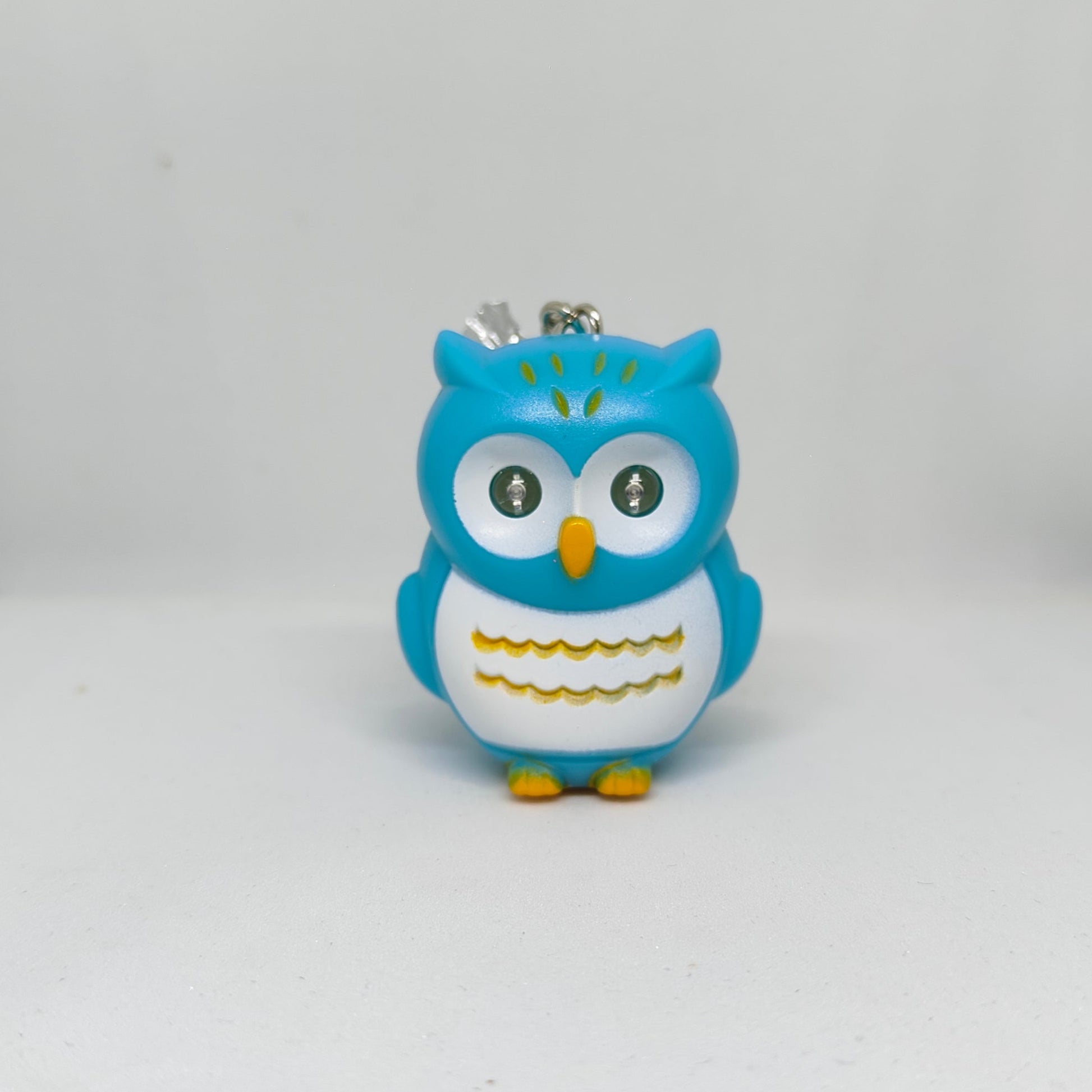 Blue owl-shaped keychain on a white background