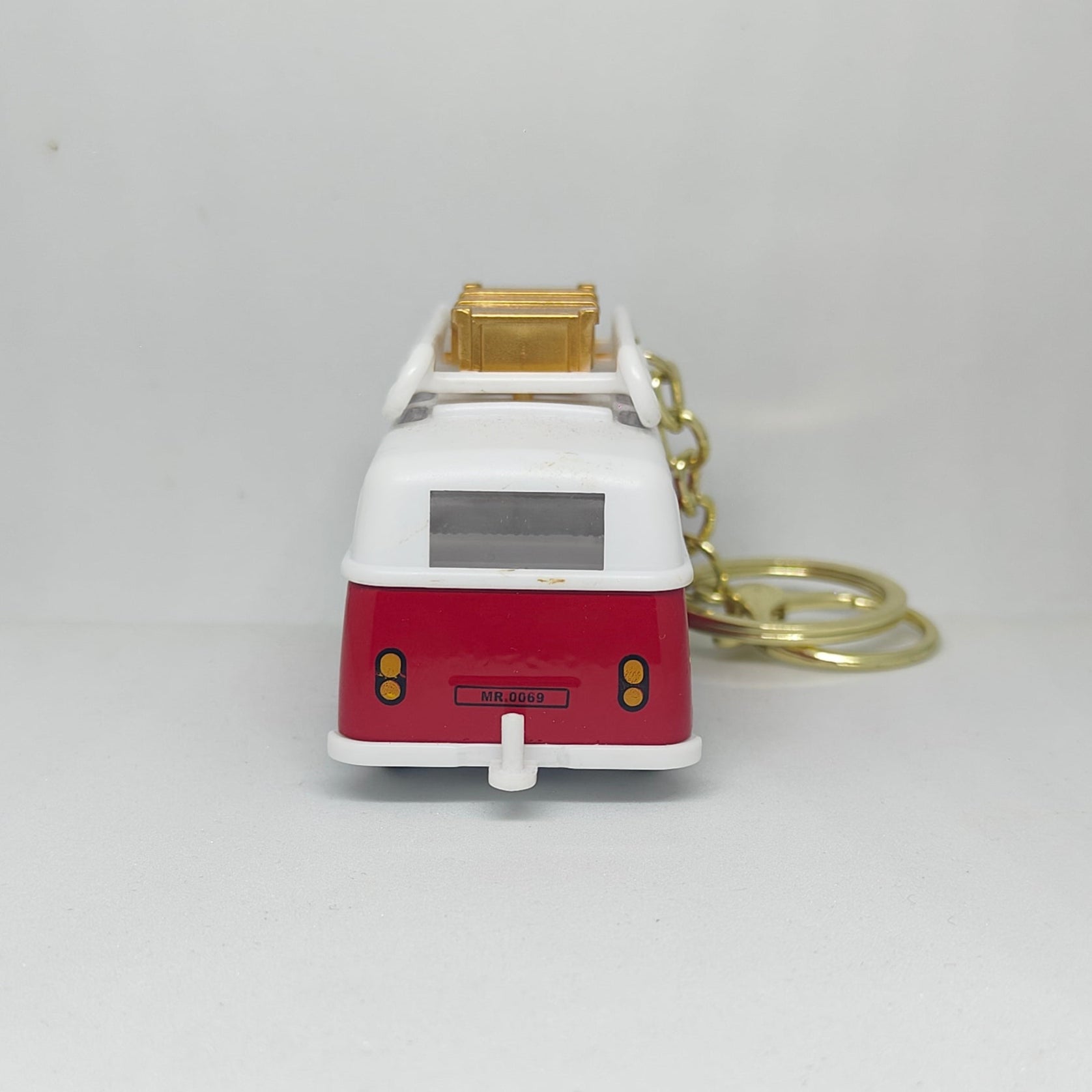 Red and white van-shaped keychain on a light gray background