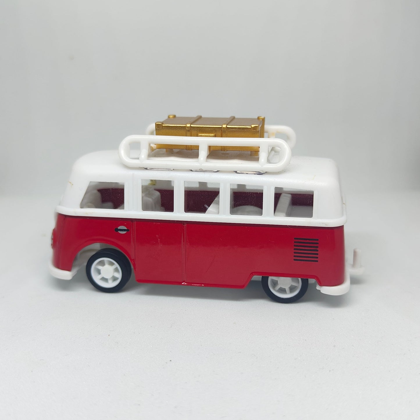 Red and white model van with a luggage rack on a light gray background