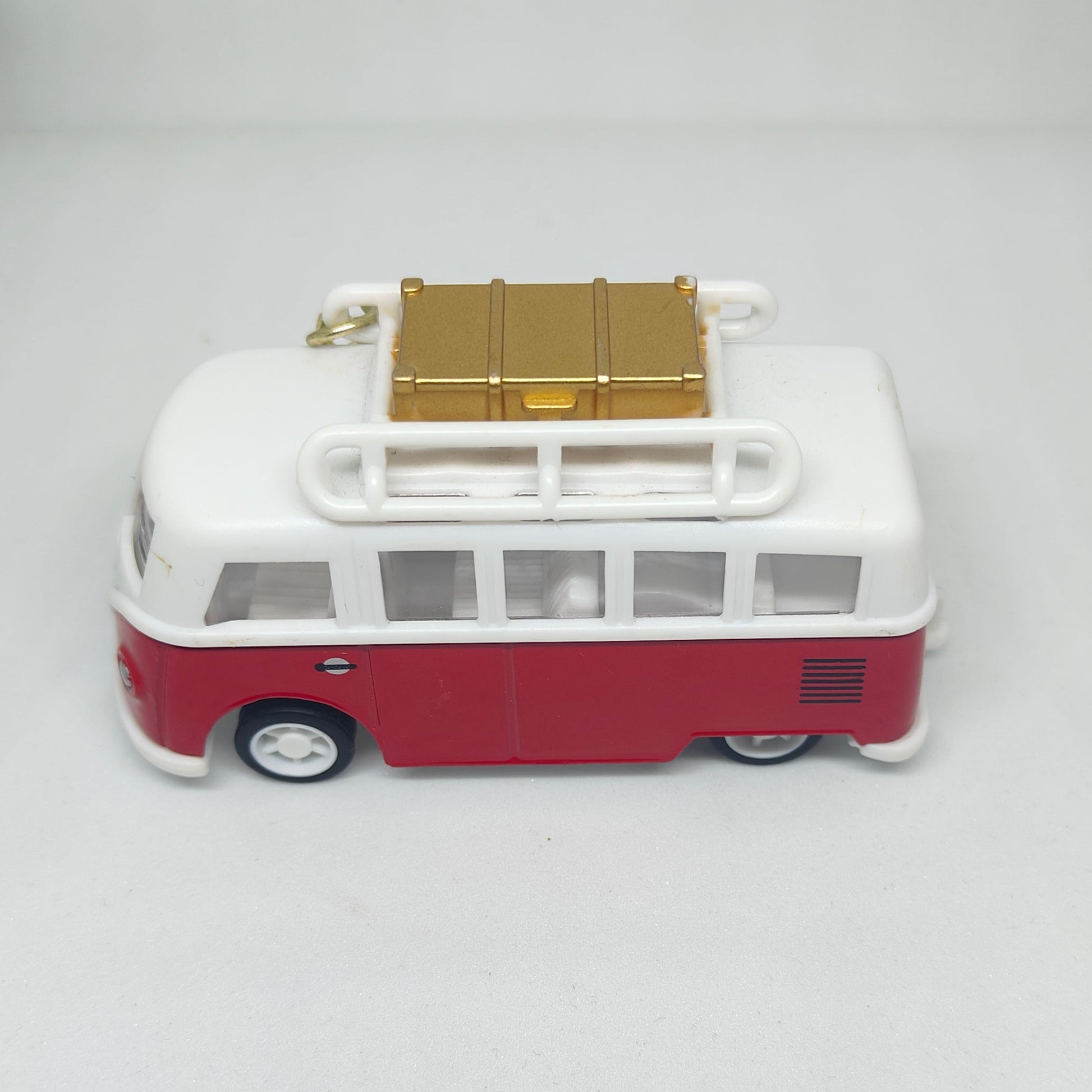Model of a vintage bus with a white body and red bottom on a gray background